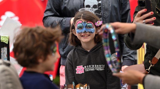 The Strickler siblings of Northfield celebrate face painting artwork done by, right, makeup artist Sharon Lippert of Wheeling at Arts on Sheridan in Highland Park on Saturday, June 14, 2025. (Karie Angell Luc/Lake County News-Sun)