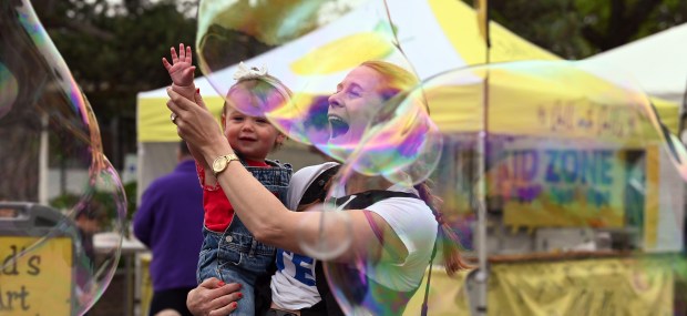 Kinsley Neville, 1, of Highwood and her mother Lily Neville have fun with bubble art at Arts on Sheridan in Highland Park on Saturday, June 14, 2025. (Karie Angell Luc/Lake County News-Sun)
