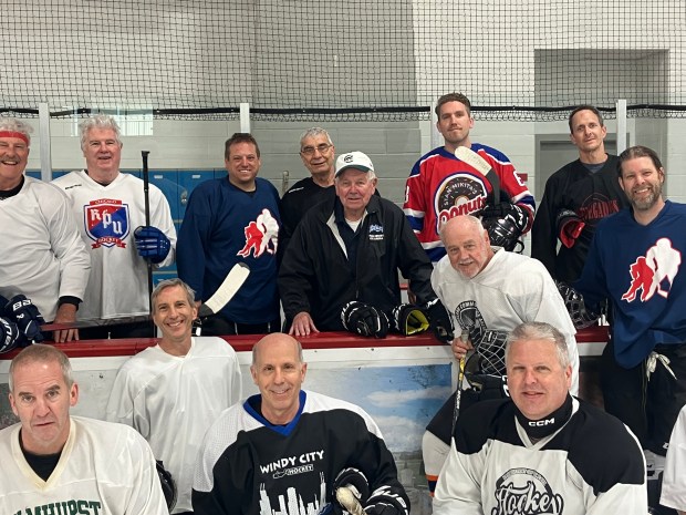 Paul Hruby, center, wearing a baseball cap, gathers with members of the 40-and-up hockey league on a recent Wednesday at the Paul Hruby Ice Arena at Ridgeland Common Park in Oak Park. (Bob Skolnik/Pioneer Press)