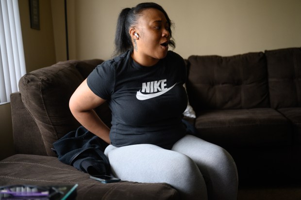 Merrillville resident Shikeia Randolph puts her hands behind her back, simulating part of an arrest that spurred her wrongful force suit against a Lake County Sheriff's police officer, as she recounts the events on Friday, June 13, 2025. (Kyle Telechan/for the Post-Tribune)