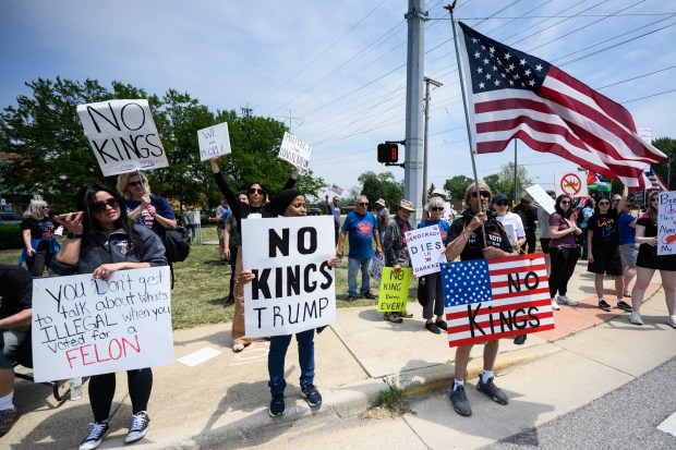 Protesters hold signs and wave flags as they gather at the corner of Indianapolis and Ridge road for the "No Kings" rally in Highland on Saturday, June 14, 2025. (Kyle Telechan/for the Post-Tribune)