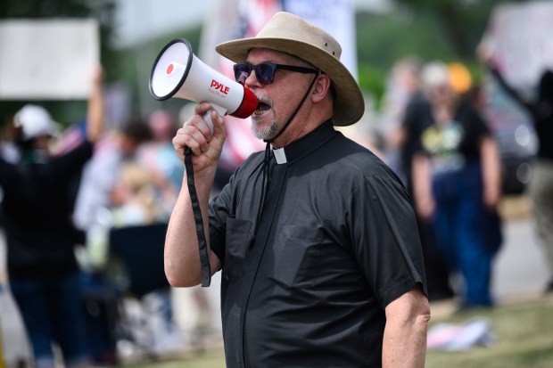Father Mark Kurowski, of The Church of Saint Raphael the Archangel in Hammond, leads a chant during the "No Kings" rally in Highland on Saturday, June 14, 2025. (Kyle Telechan/for the Post-Tribune)