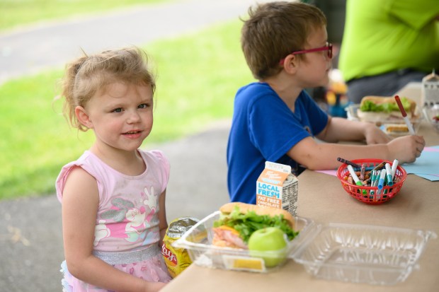 River Forest student Evalynn Smith, 4, and her brother Cephas, 6, eat lunch together during a summer meals program at Twin Oaks Park in New Chicago on Thursday, June 12, 2025. (Kyle Telechan/for the Post-Tribune)