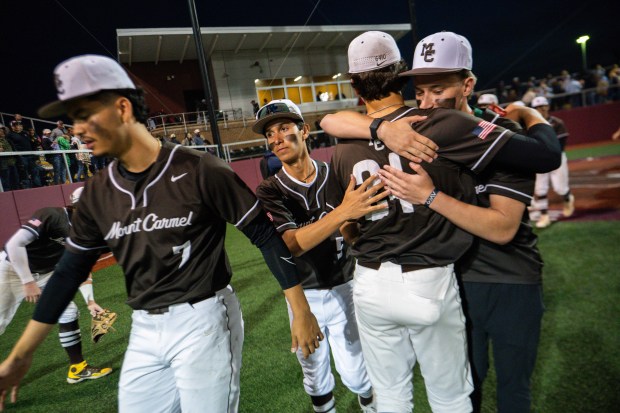 Mt. Carmel junior Jake Matise (24, right) hugs teammate junior Ian Tosi (27) after the team won the Mount Carmel vs. Nazareth Class 4A Reavis Sectional baseball semifinal at Triton College in River Grove, IL on Wednesday, June 4, 2025. (Andrew Burke-Stevenson/for the Daily Southtown)