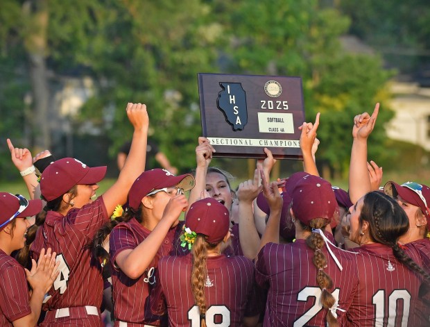 Lockport pitcher Kelcie McGraw (middle) holds the Sectional Championship plaque aloft after winning the Class 4A Lockport Sectional final game against Lincoln-Way Central on Friday, June 6, 2025 in Lockport.(Jon Cunningham for the Daily Southtown)