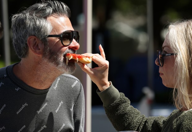 Jeramie Ryan is offered a bite of pizza from his wife, Jenna, at the Taste of Chicago on Sept. 7, 2024, in Chicago.(John J. Kim/Chicago Tribune)