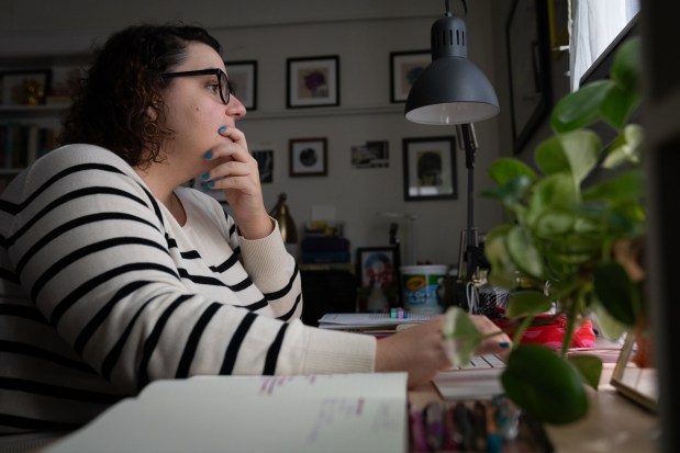 Oriette D'Angelo grades her students class assignments while in her home in Iowa City, Feb. 27, 2025. (Audrey Richardson/Chicago Tribune)