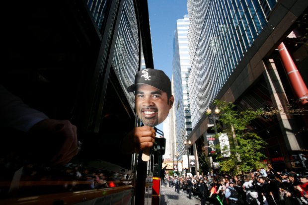 One of the many masks of Chicago White Sox manager Ozzie Guillén passed out by the City of Chicago, pops out as one of the double-decker buses as it makes its way down the parade route celebrating the team's World Series victory. In the Loop on Oct. 28, 2005. (José Moré/Chicago Tribune)