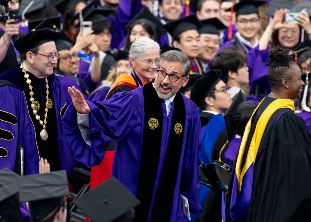 Actor-comedian Steve Carell waves to graduates during Northwestern University's commencement, June 15, 2025, at the United Center. University President Michael Schill is at left. Carell was the commencement speaker and is the father of a Northwestern student. (Brian Cassella/Chicago Tribune)