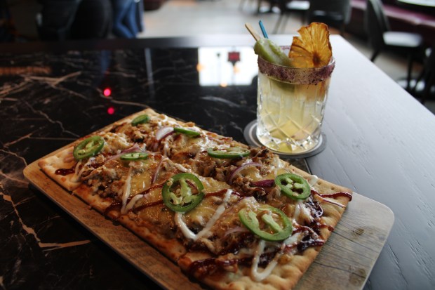 The Skokie location of Puttshack offers a variety of bar food, including The Pitmaster flatbread with smoked chicken, bbq sauce, smoked gouda, red onion, jalapeño and ranch, and the Spiced Pineapple Mezcal Margarita. (Richard Requena/Pioneer Press)